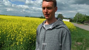 Cutesy young man tempted next to a field of flowers